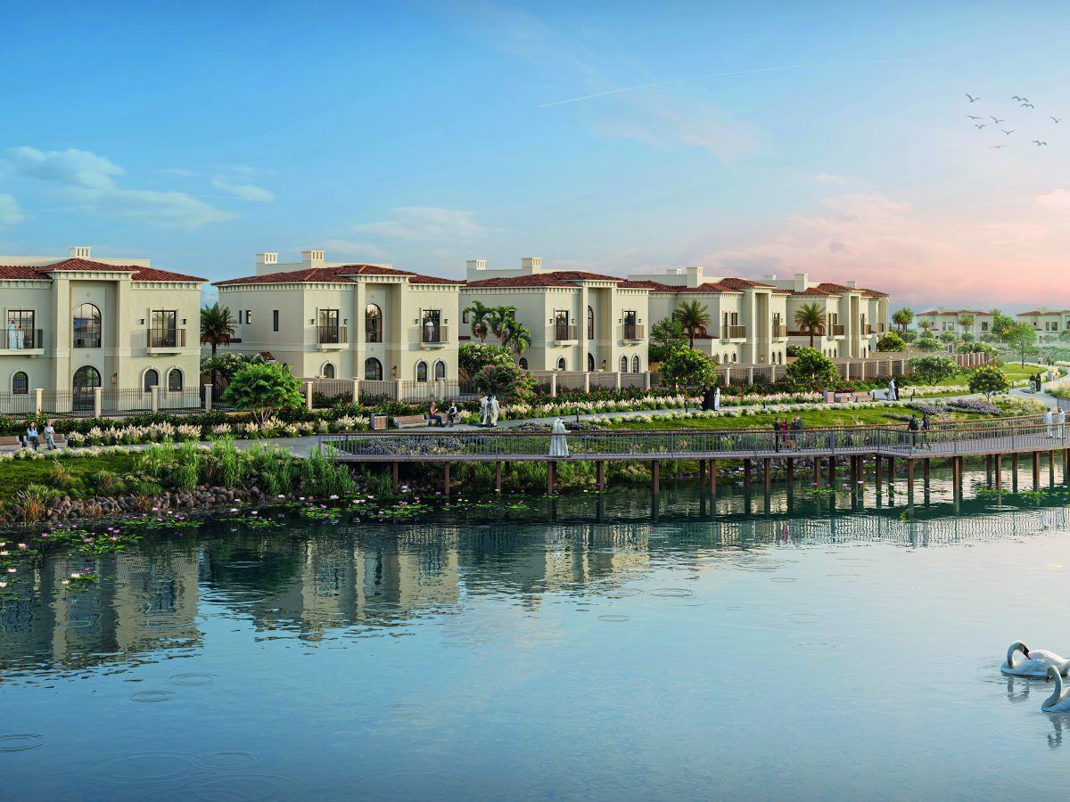 Townhouses beside a lake at sunset in a landscaped community
